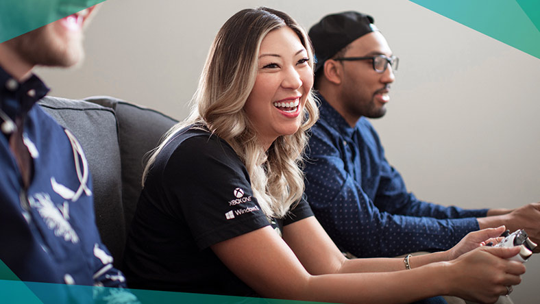 Three people smiling with controllers in their hands