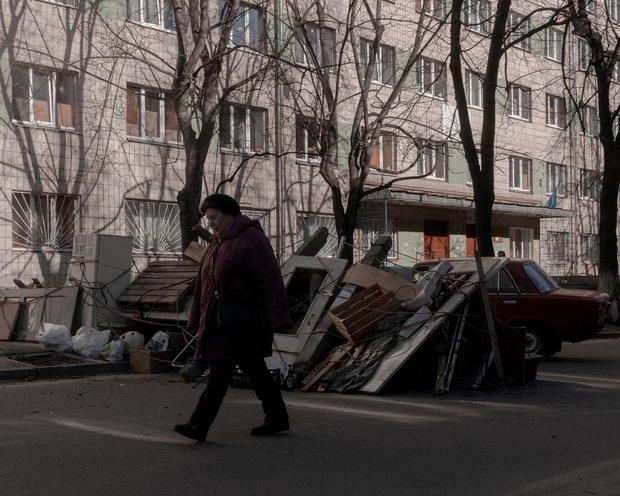 A woman walks past a street barricade in Kyiv 