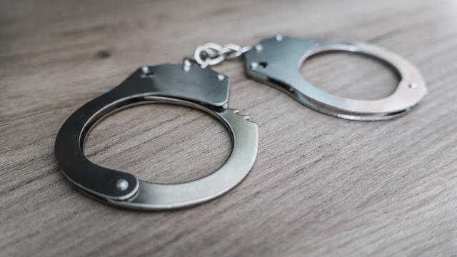 the concept of arrest and crime. handcuffs on a wooden table 