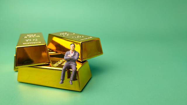 Gold bar with miniature people, Business and financial concept 