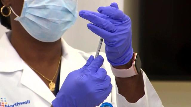 A health care worker prepares a vaccine. 