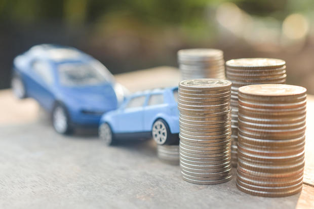 Coins stack and car model on wood table 