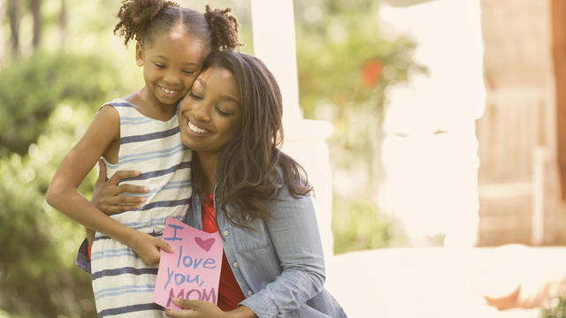 Girl gives card to mother 