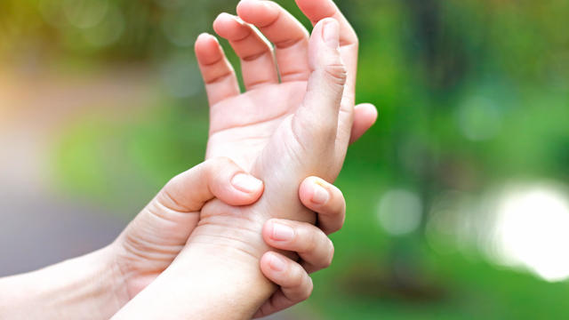 Woman holding hand to spot of wrist pain 