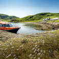 a red boat pulled up to an island 