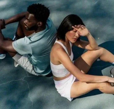 man and woman sitting down on tennis court