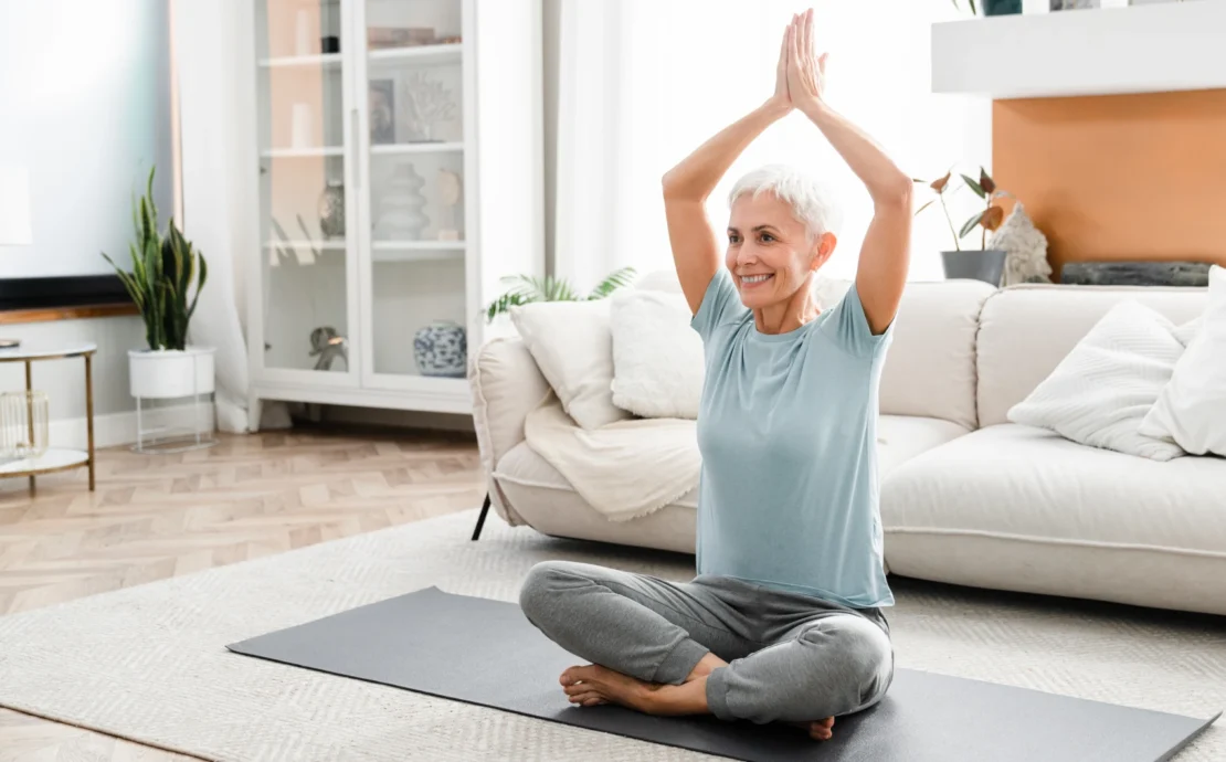 older woman doing yoga at home