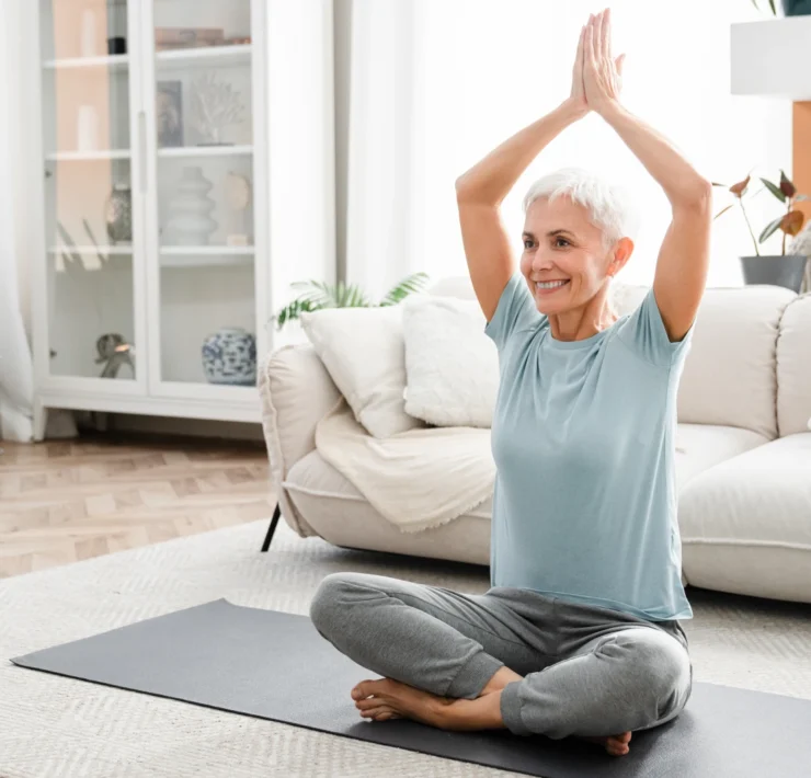 older woman doing yoga at home