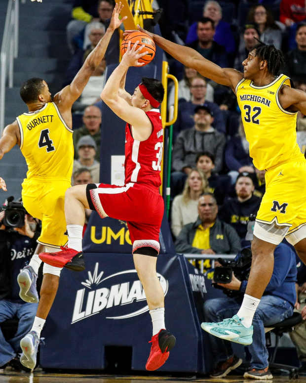 Nebraska guard Keisei Tominaga makes a layup against Michigan's Nimari Burnett and Tarris Reed Jr. during the first half at Crisler Center in Ann Arbor on Sunday, March 10, 2024.  