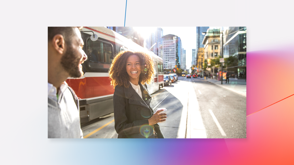 A young man and woman greet each other on a downtown sidewalk while commuting to work in the morning.