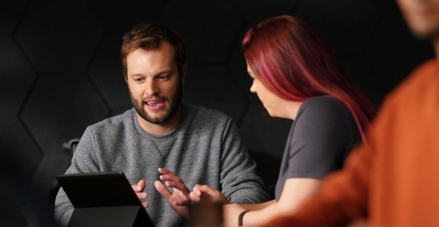 Two Basis employees looking at a laptop and talking.