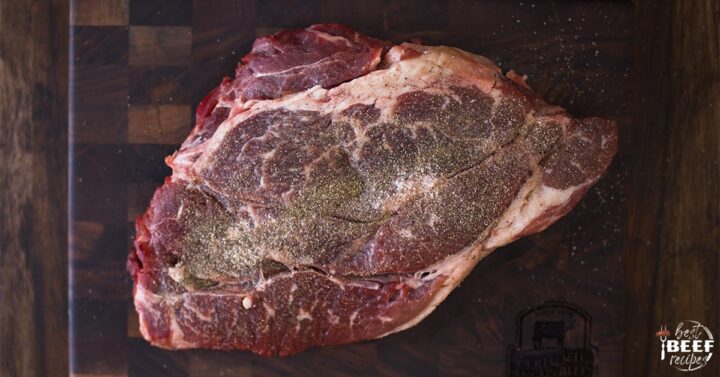 Seasoned beef chuck roast on a cutting board