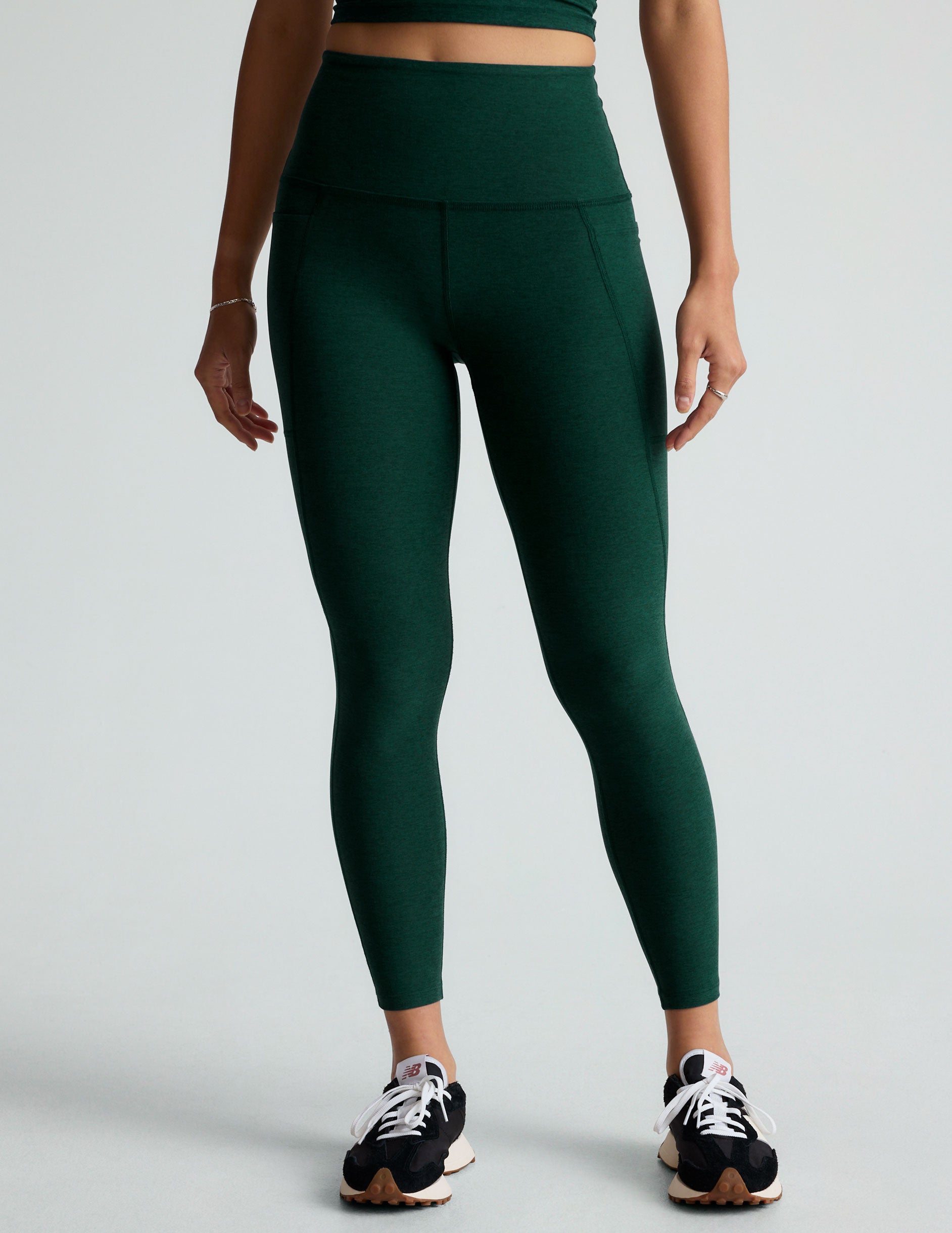 green high-waisted midi leggings with side pockets. 