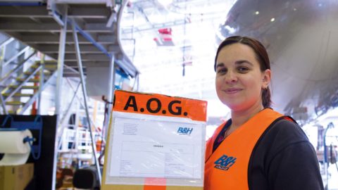 woman delivering AOG box in hanger