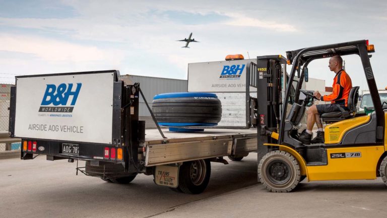 forklift loading aircraft wheel onto truck