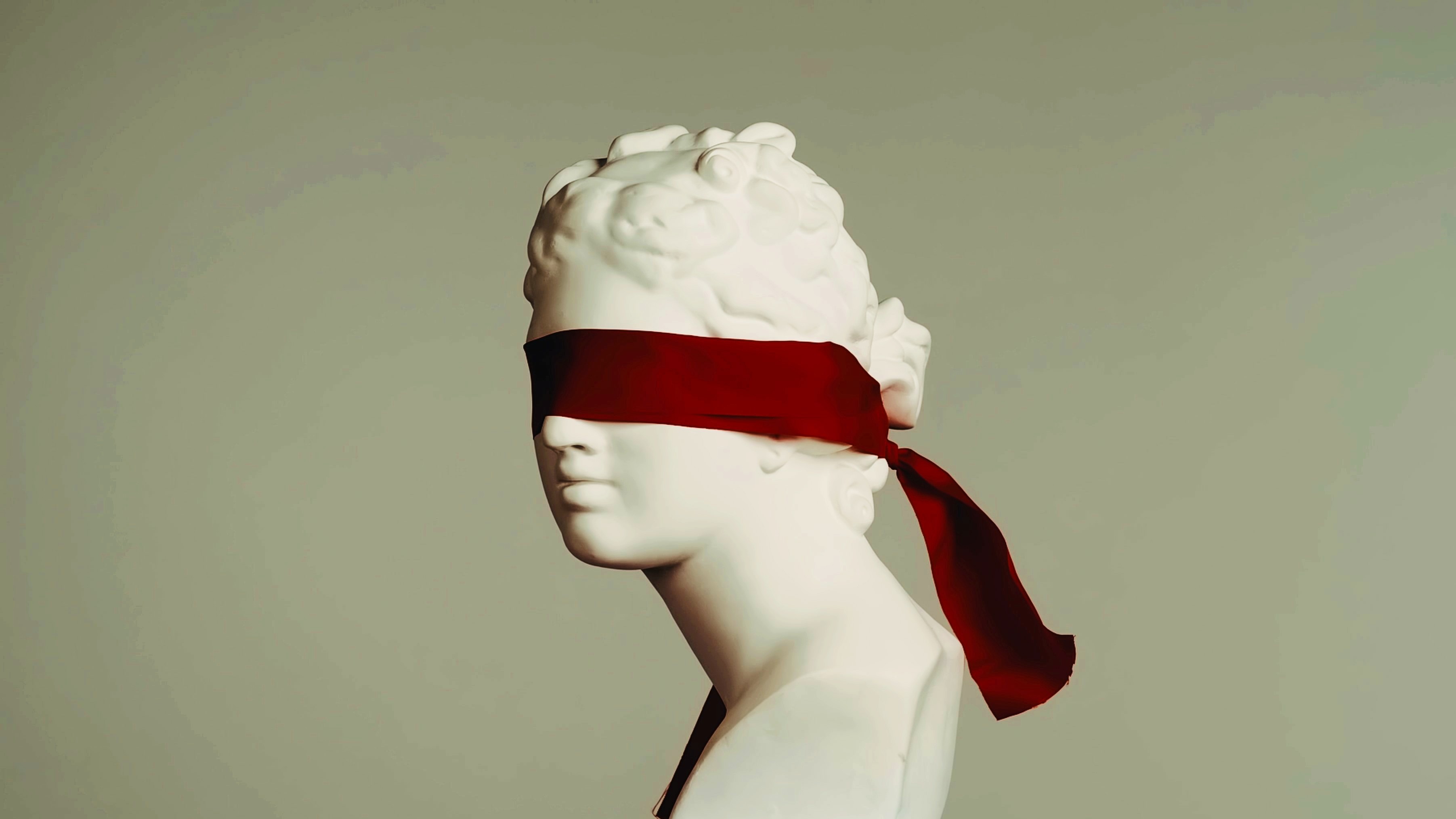 A statue of a woman with a red blindfold on her head, symbolizing the human experience in the realm of science.