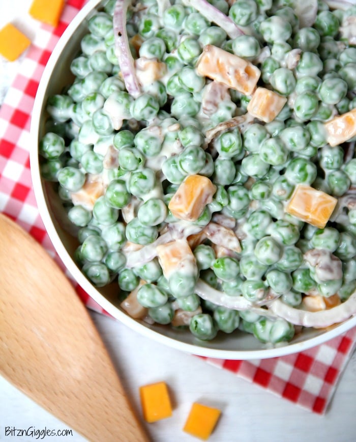 Easy Pea Salad - A summer salad perfect for potlucks and gatherings. Crisp green peas float alongside bacon, cheddar cheese and thinly sliced red onion in a sweet and creamy dressing.