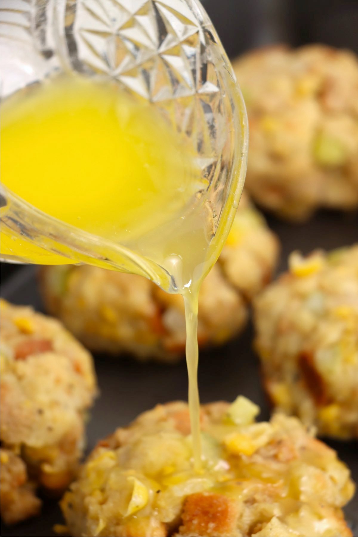 Pouring melted butter over Thanksgiving dressing balls