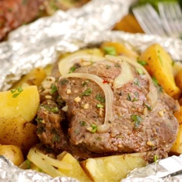 Steak, potatoes and onions in a foil packet.