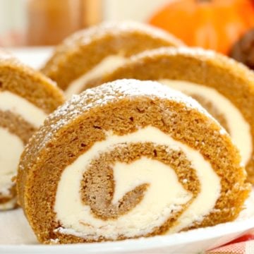 Four slices of a swirled pumpkin roll on a white serving plate.