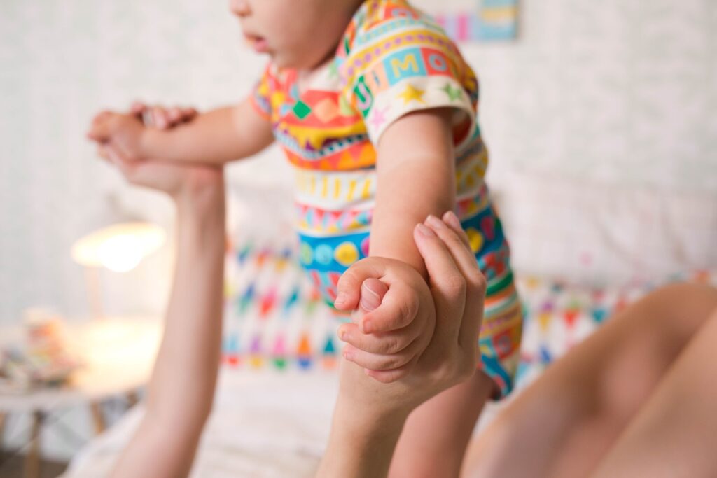 Mãe deitada com bebê em cima