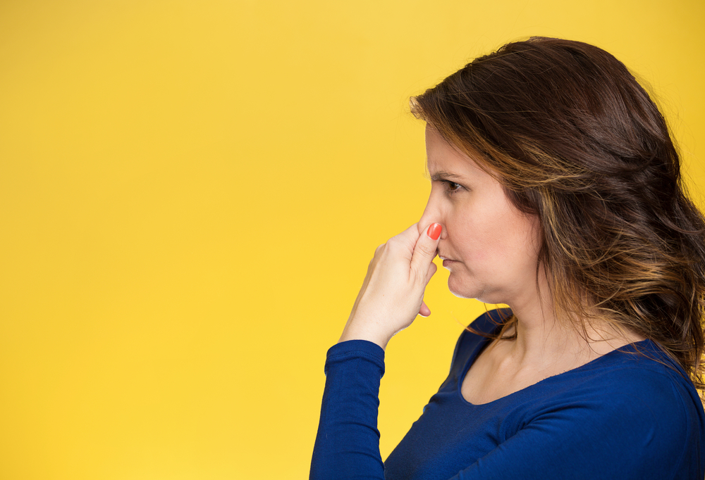 Side view profile portrait middle aged woman covers pinches her nose with hand looks with disgust, something stinks bad smell situation isolated yellow background. Human face expression body language-2