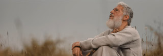 Samuel, portrayed as a older middle aged man with white hair and a beard sit and talks to God in a screen grab from the film