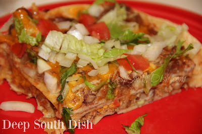 A Tex-Mex casserole made from seasoned shredded pork, chicken or beef and beans, layered with corn tortillas, cheese and taco sauce and finished with chopped onion, tomato and shredded lettuce.