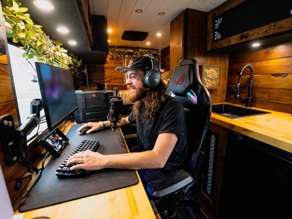 Man in van playing video games on desk