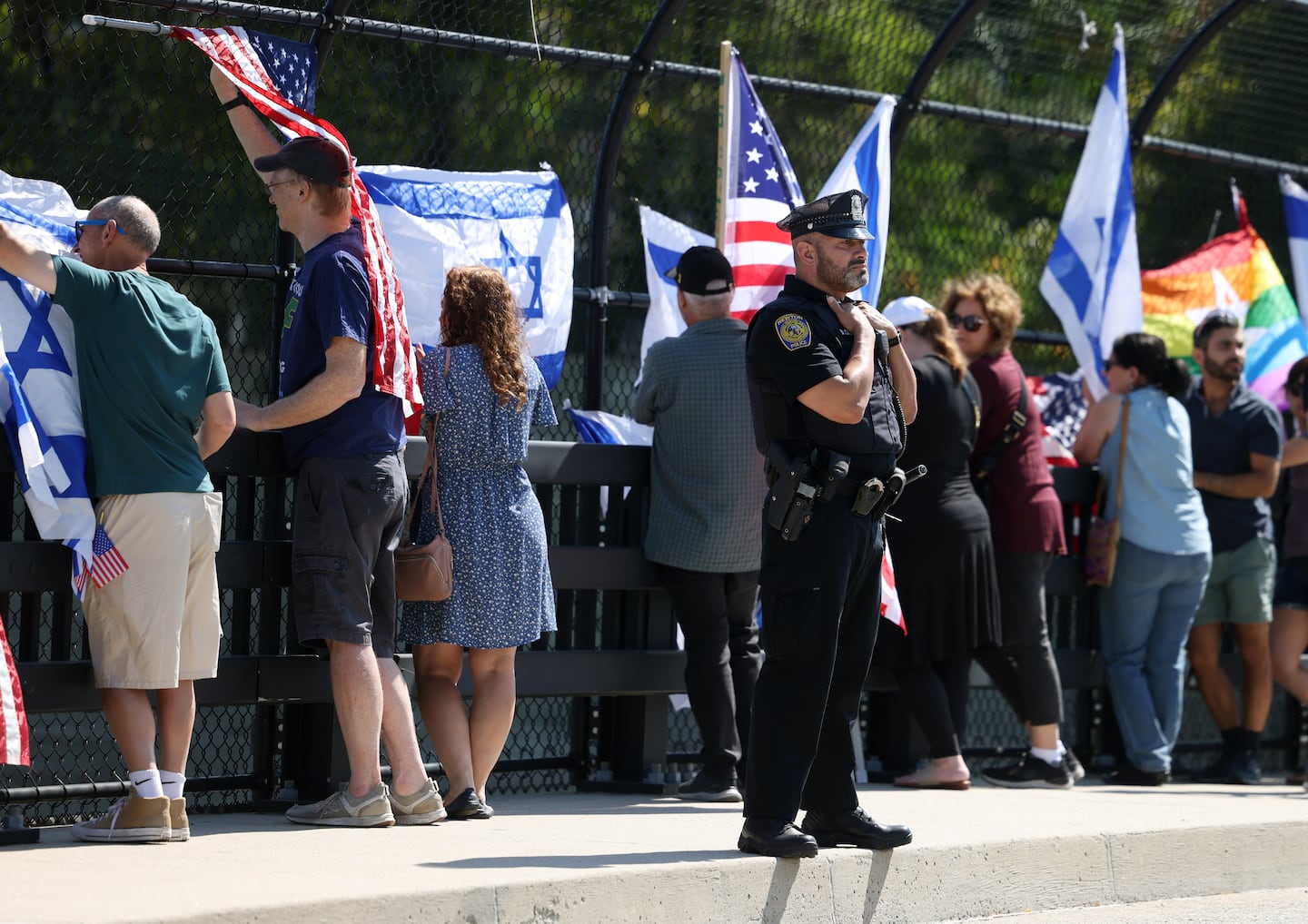 A Newton police officer stood watch as protesters rallied on the Harvard Street overpass along the Mass Pike in Newton on Sunday.