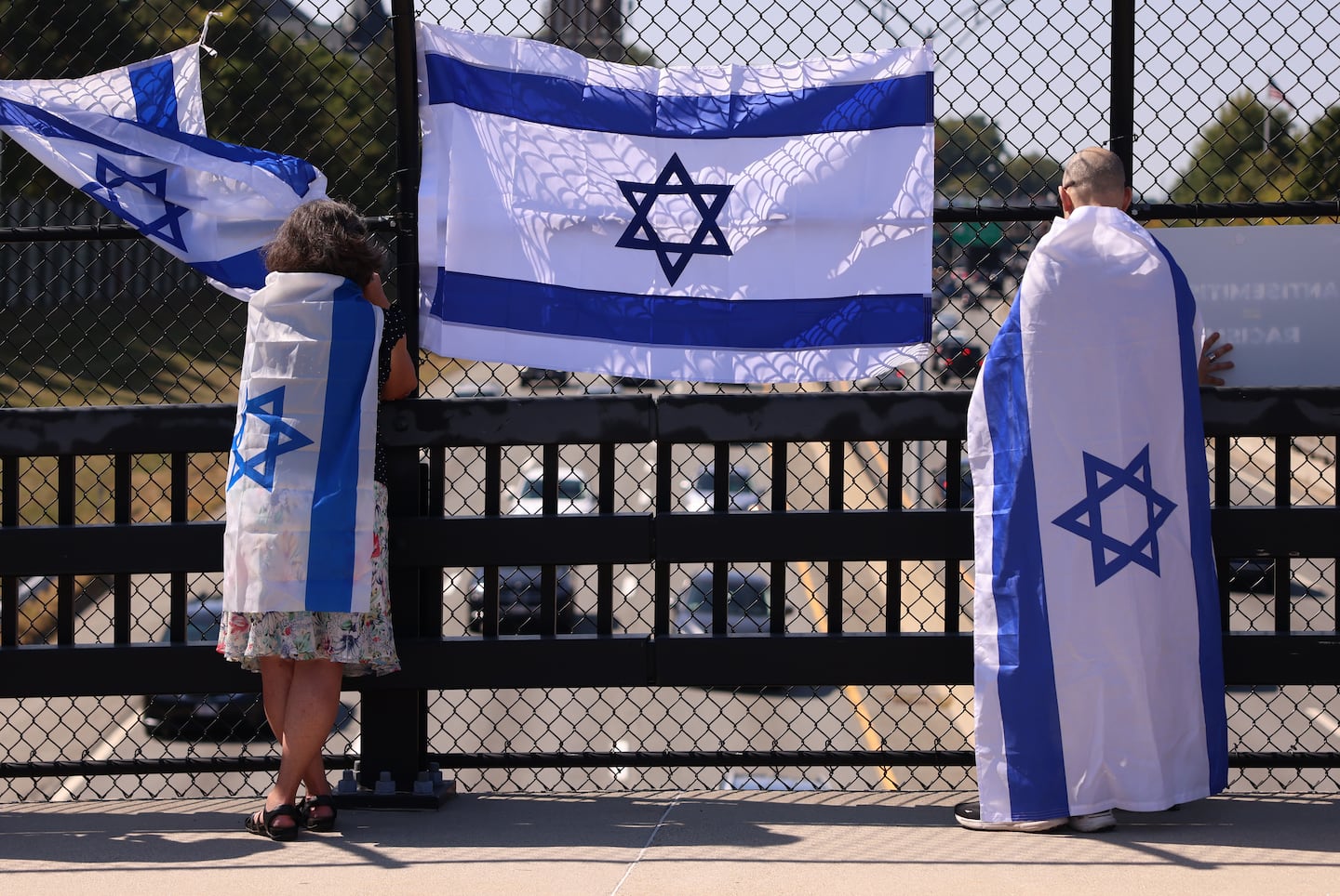 Protesters on the Harvard Street overpass along the Mass Pike on Sunday after gathering at the Newton Centre Green to rally for Israeli hostages still being held by Hamas.