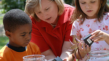 Photo of a woman teaching two young children