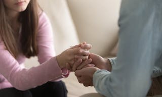 Close up view of upset couple, guy holding hands of crying woman, trying to comfort and console her, boyfriend apologizing offen