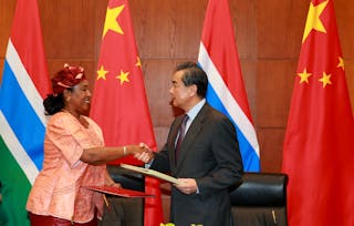 China's Foreign Minister Wang Yi (R) shakes hand with his Gambian counterpart Neneh Macdouall-Gaye at a signing ceremony in Beij