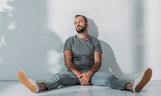 Full length view of depressive bearded middle aged man sitting on floor and looking away — Photo by AndrewLozovyi