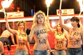 German activists from women's rights organisation Femen hold torches as they demonstrate against prostitution in Herbert-Street 