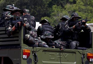 People's Liberation Army (PLA) soldiers sit on a military vehicle during an anti-terrorist drill, at a PLA naval base in Hong Ko