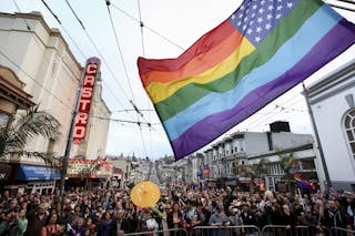 A rainbow-colored U.S. flag flies in front of San Francisco's iconic Castro Theater during a street celebration following the Un