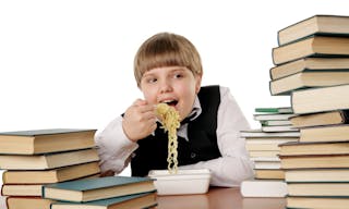 boy eating chinese instant noodles isolated on white