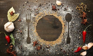 Spices on table with cutlery silhouette, close-up