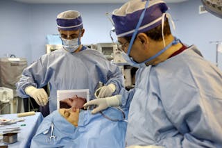 Iranian surgeon Ali Manafi performs a surgery on the nose a female patient in the operating room at a hospital in Tehran