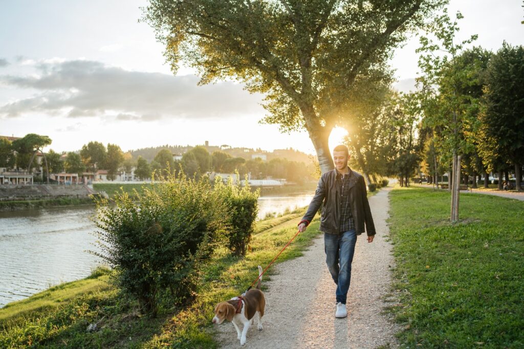 Young man walking dog near a lake