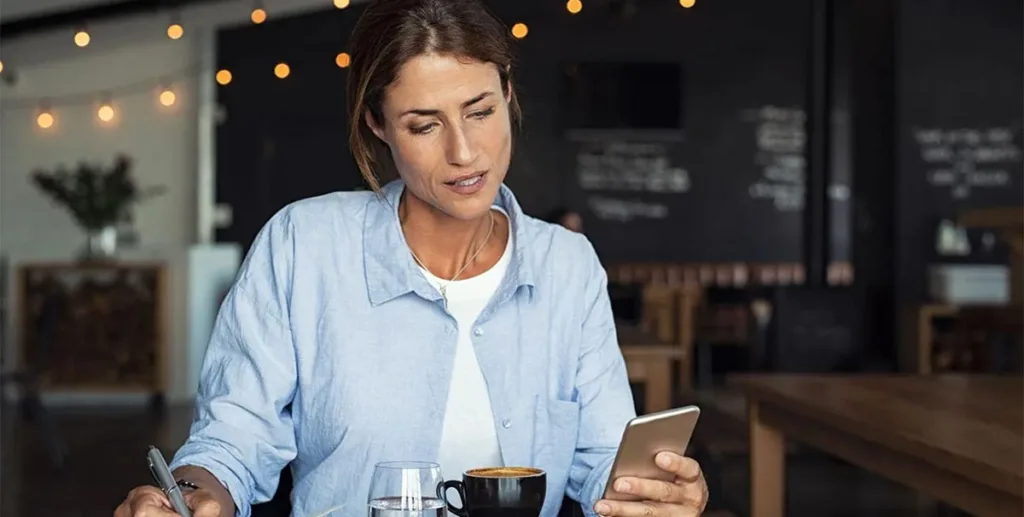 Advantages of online advertising: business owner in cafe using phone