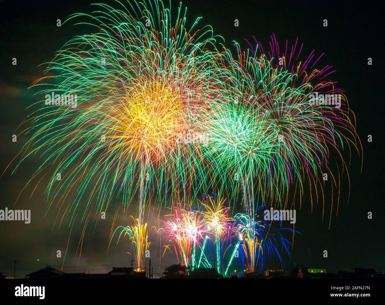 Colorful fireworks. Fireworks are a class of explosive pyrotechnic devices used for aesthetic and entertainment purposes. Visible noise due to low Stock Photo