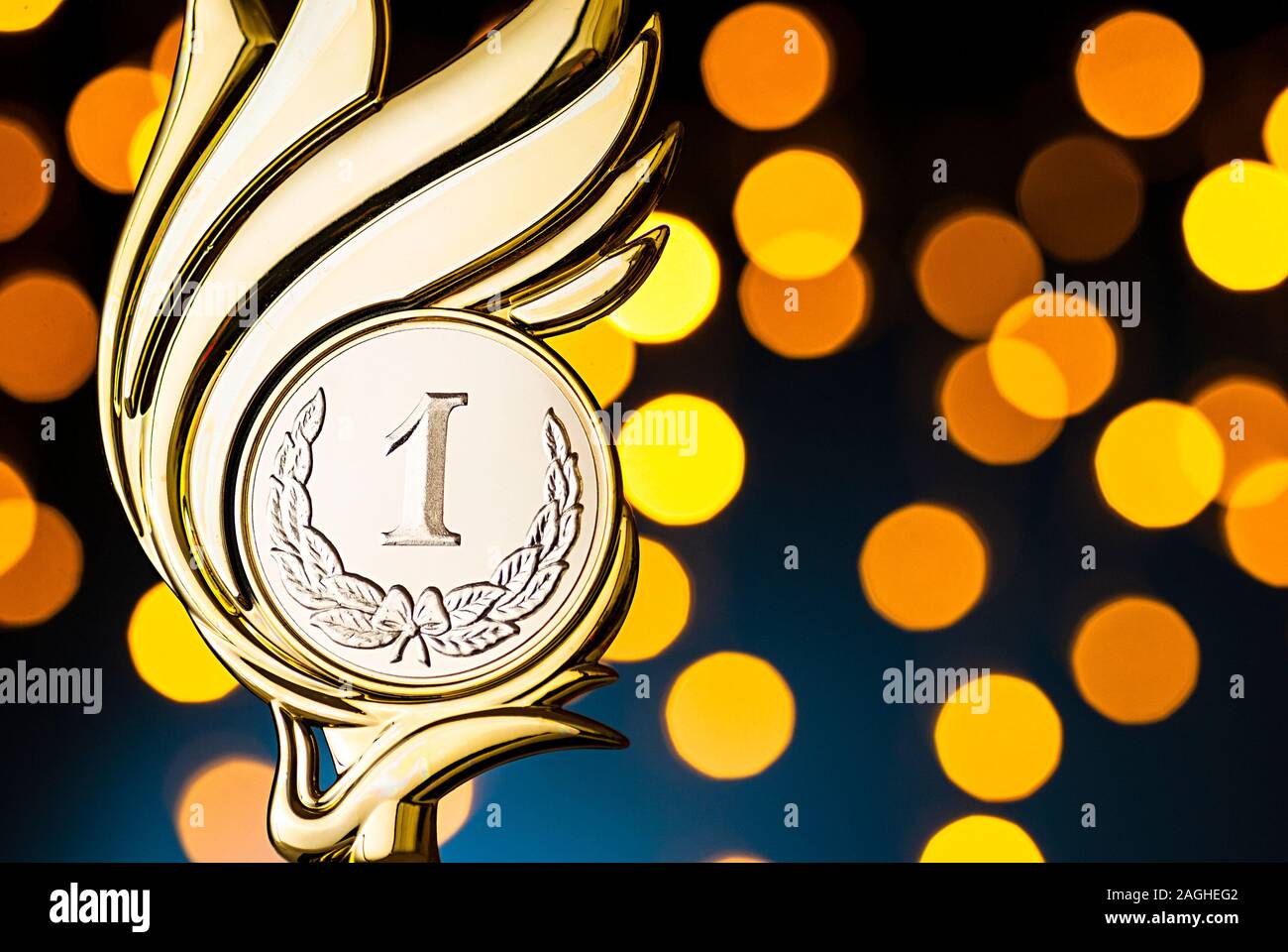 Gold trophy award with flaming medallion event over a blue background Stock Photo