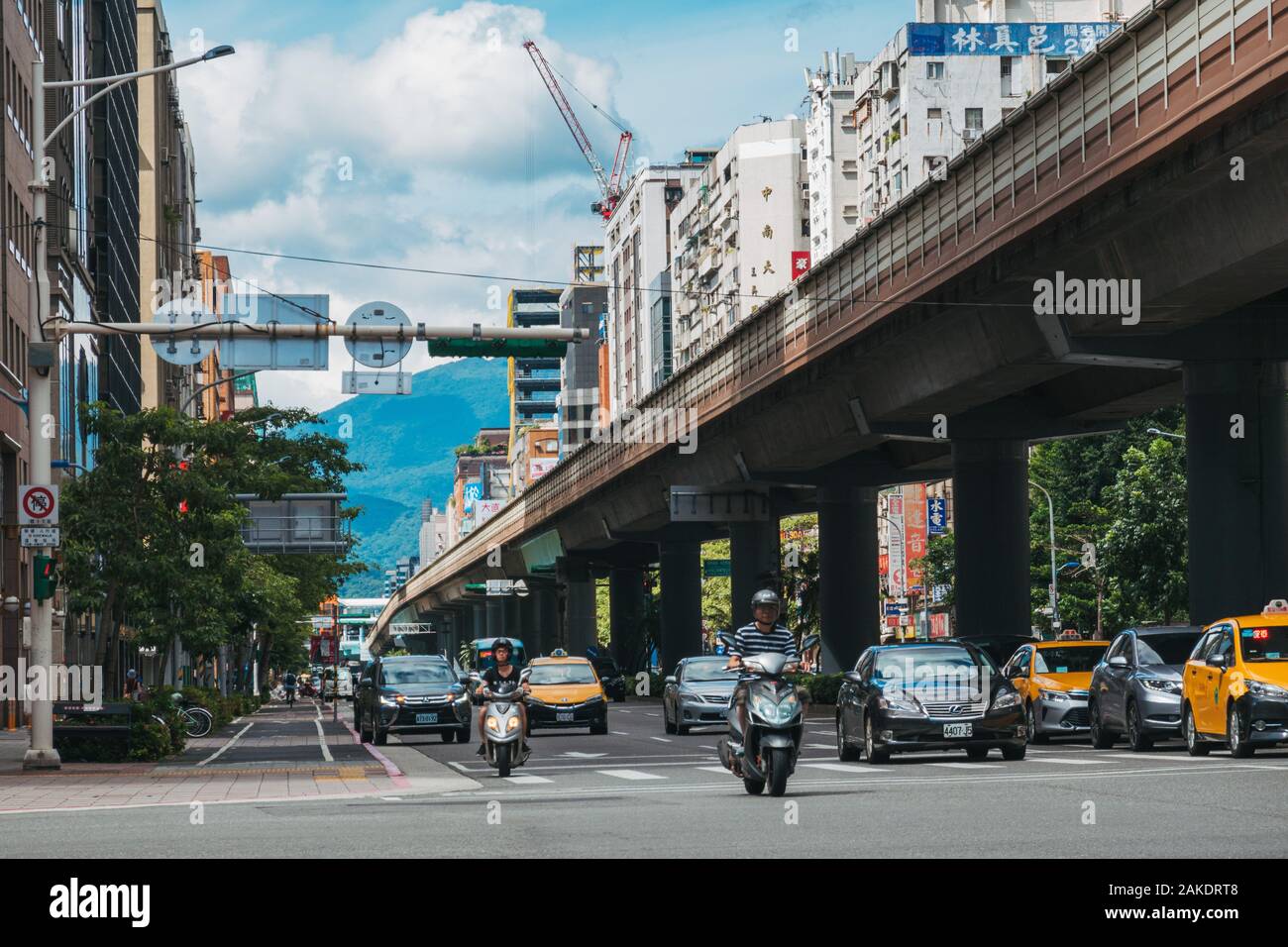 Traffic drives parallel to an elevated section of track on Taipei Metro near Daan Station Stock Photo