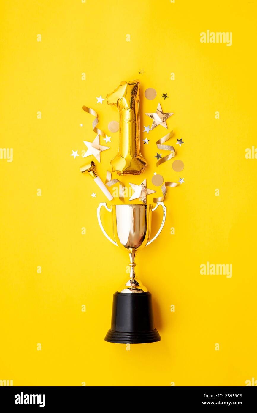 Number 1 gold anniversary celebration balloon exploding from a winning trophy Stock Photo