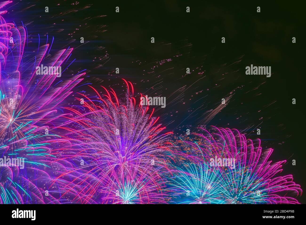 Vivid purple fireworks with sparks on dark sky. Explosive pyrotechnic devices for aesthetic and entertainment purposes, art. Colored fireworks Stock Photo