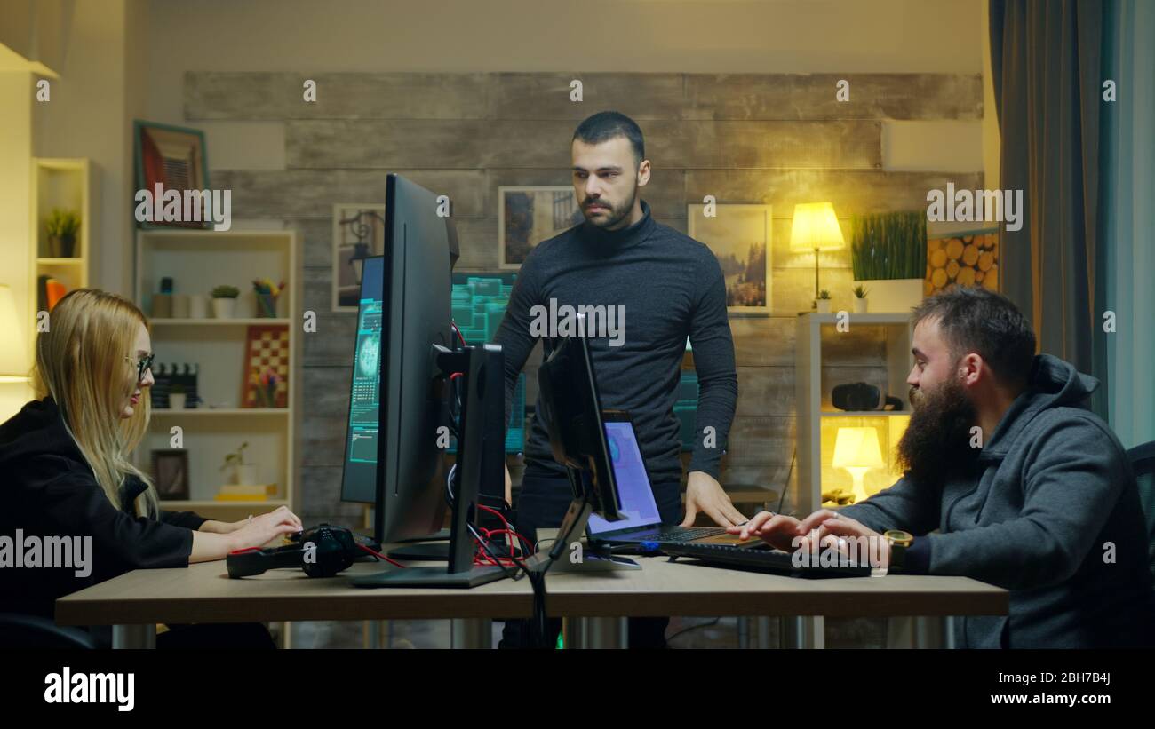 Dangerous hacker with his team doing cyber crimes from his apartment. Stock Photo