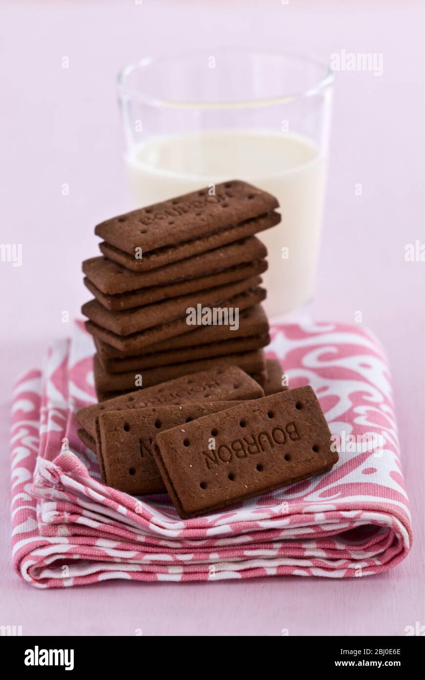 Bedtime snack of a glass of cold fresh milk with bourbon chocolate biscuits - Stock Photo